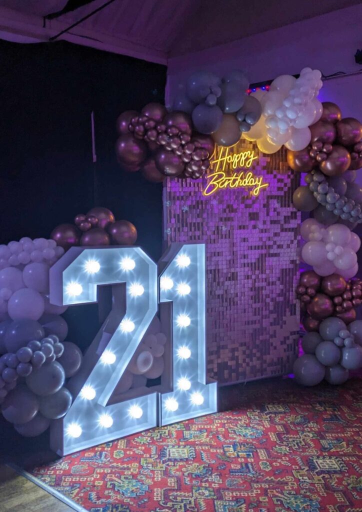 21st birthday balloon backdrop with balloon garland, sequin wall and illuminated number 21