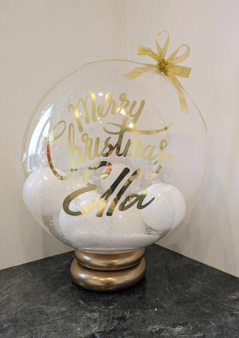 Clear personalised christmas bubble balloon with gold lettering and festive decoration