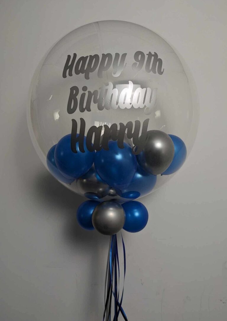 Clear personalised birthday bubble balloon filled with blue and silver balloons