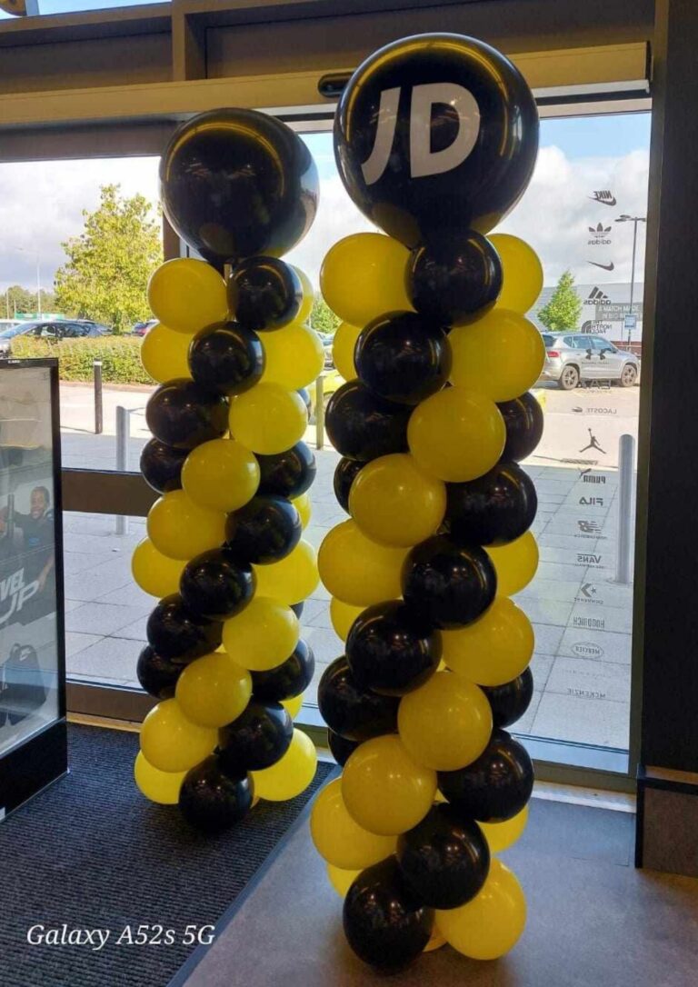 Black and yellow balloon columns with branded balloons displayed inside a retail store entrance