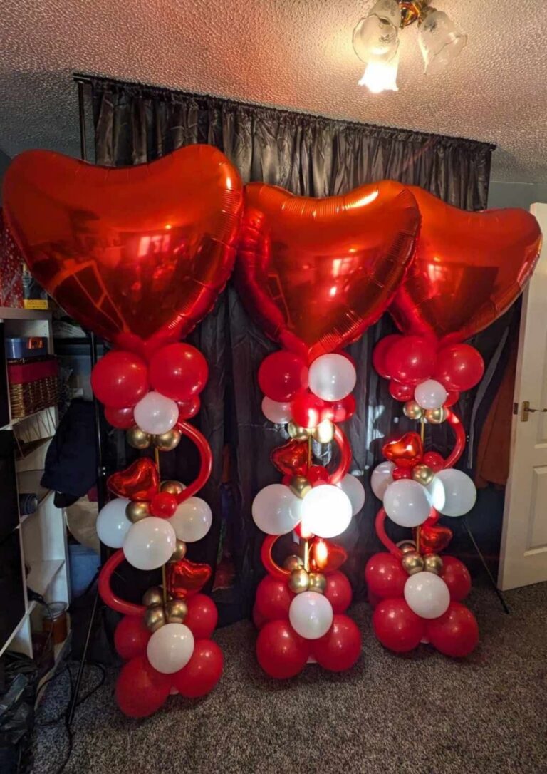 Red heart foil balloon displays arranged as decorative balloon towers for a valentines celebration